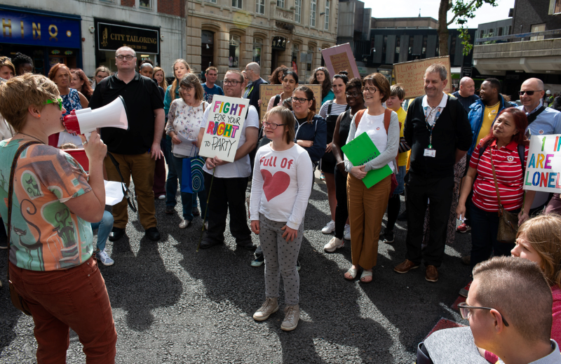 A crowd of onlookers, including Grapevine CEO Clare Wightman, listens to community organiser Gemma share a story at a walk and talk through Coventry city centre in August 2019.