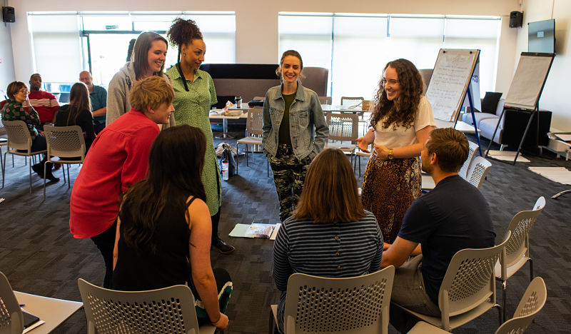 Grapevine team members sit and stand in a circle at a team away day